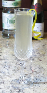 French 75 cocktail in a champagne flute garnished with a lemon twist